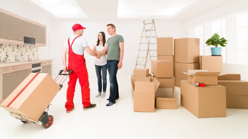Moving team transporting large furniture items through a Lewisham property